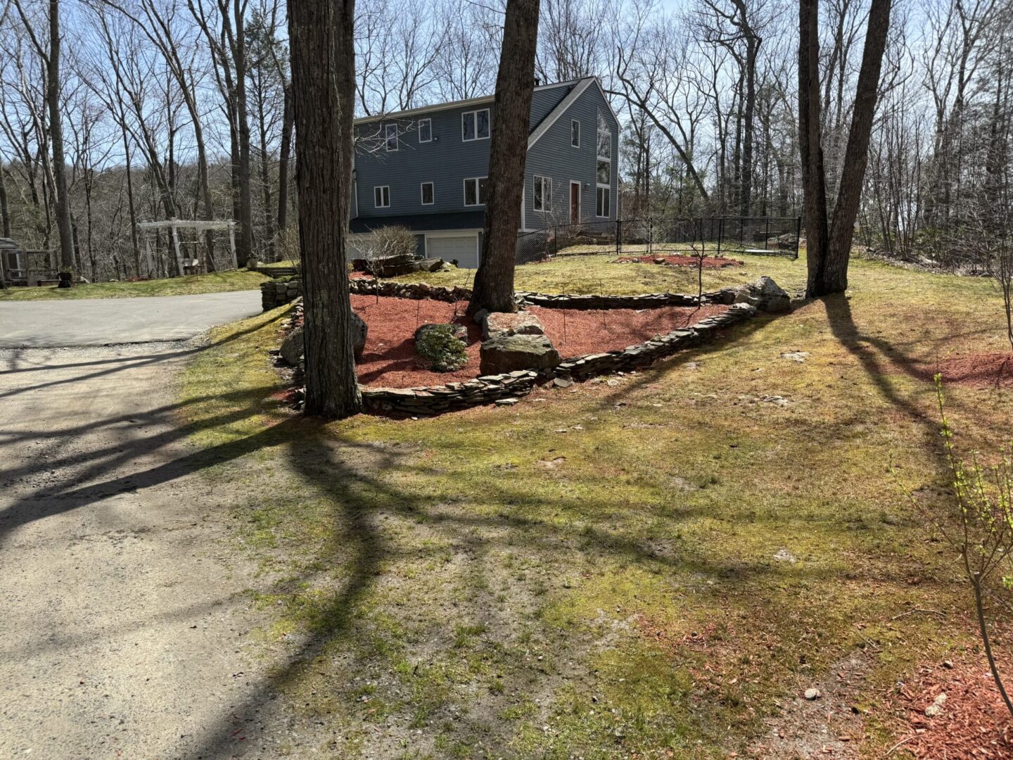 A yard with trees and grass in the middle of it